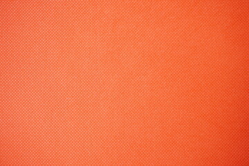 Orange textured background with a small geometric pattern and subtle details