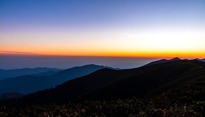 Fototapeta premium A breathtaking panorama of mountain ranges at sunrise, showcasing a vibrant color gradient across the sky and rugged terrain.