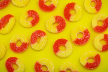 Sugary Peach Ring Gummies Candy Spread on bright yellow background 