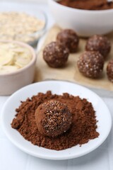 Making homemade candies. Chocolate balls and ingredients on white table, closeup