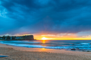 Winter sunrise by the sea shore with rain clouds