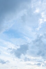 Light blue sky with scattered cumulus clouds Vertical image of a partly cloudy daytime sky