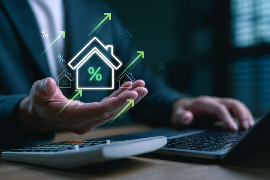 Rising home loan interest rates concept with digital house icon and upward arrows. Businessman analyzing mortgage trends, housing market and real estate financial planning with calculator.