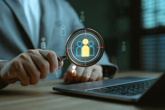 Businessman analyzing target audience with magnifying glass and digital interface. Concept for customer targeting, market segmentation, recruitment strategy and data-driven decision-making.
