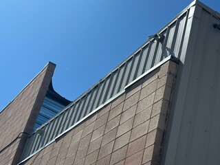 Modern Industrial Building Exterior with Brick and Metal Facade Against Clear Blue Sky – Urban Architecture Detail