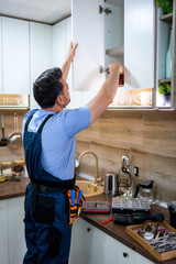 Home improvement project in a modern kitchen with a worker organizing cabinets