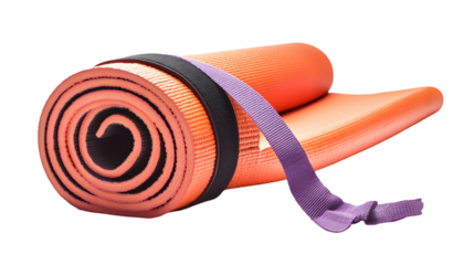 A rolled up orange yoga mat secured with a black band and a purple strap on a black background