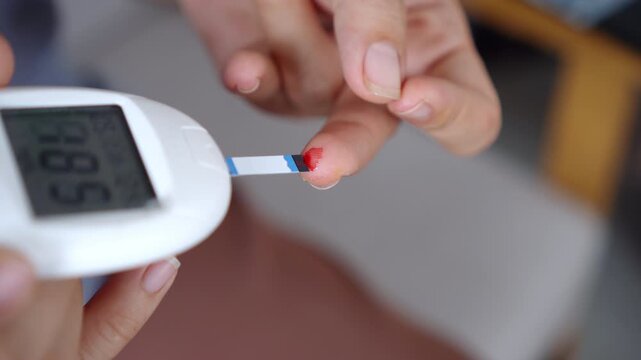 Asian woman holding a plate and checking blood sugar level with a glucose meter on her finger, monitoring high blood sugar, diabetes control, and health care concept 