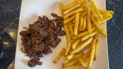 A plate of traditional flemish beef stew (carbonnade flamande) with french fries