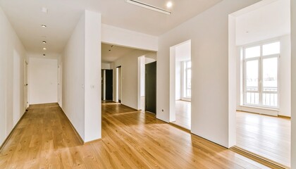 Obraz premium An empty hallway leads to spacious rooms with large windows, showcasing a modern, bright interior design.