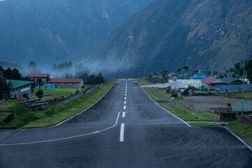 An aircraft before landing on the runway in Lukla airport the most dangerous airport in the world in Nepal. The runway rests on a hillside in the town of Lukla, Nepal.
