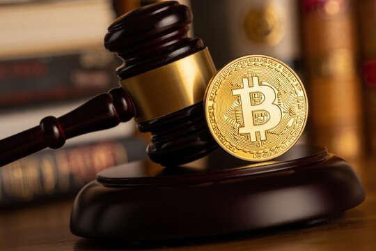 Golden bitcoin coin with judge's gavel symbolizing financial justice