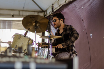 Homem tocando bateria com  concentração