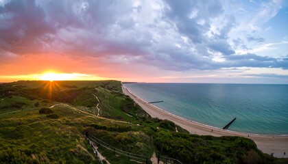 A breathtaking panoramic view of a coastal landscape at sunset, showcasing a dramatic interplay of vibrant colors, rolling hills, a serene beach, and a vast ocean.
