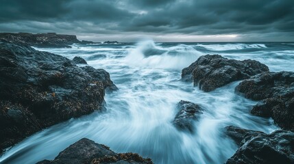 Dramatic ocean waves crash against dark volcanic rocks under a stormy sky