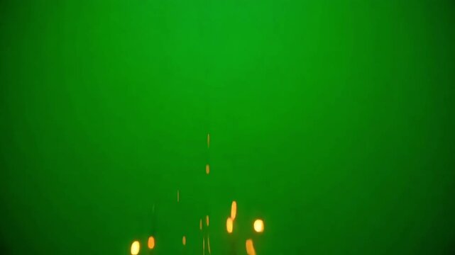 Dynamic golden particles falling against vibrant green chroma key background