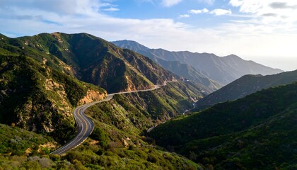 Winding Mountain Road Through Lush Green Valleys Under a Bright Sky.
