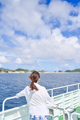 船から美しい沖縄の海を眺める女性の後ろ姿