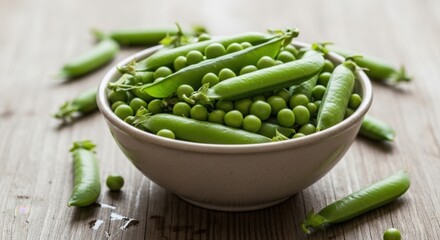 Fresh green peas in a bowl on a wooden table.
