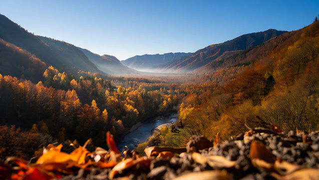 Majestic mountain valley bathed in golden autumn light with a gentle mist rising from the river below showcasing vibrant fall foliage and a clear blue sky above