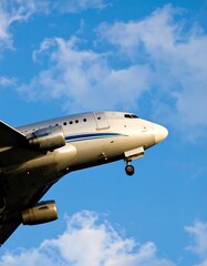 Airplane in flight against a partly cloudy blue sky
