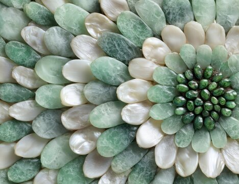 Detailed close-up of a mosaic flower design made of green and white stones and shells