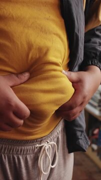 A big man touching his stomach with fat belly