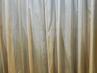 Soft, flowing curtain fabric displaying elegant vertical pleats, creating a serene and...