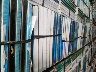 A dense collection of aged books and academic journals stacked vertically on shelves, preserving a...