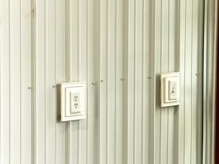 white switch and outlet on a white metal wall
