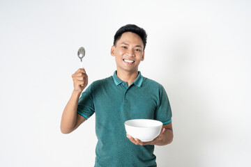 A cheerful individual stands with a spoon and bowl, showcasing a joyful and engaging moment.