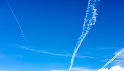High-altitude contrails crisscrossing a vast, vibrant blue sky.
