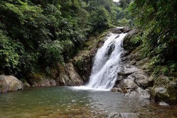 crystalclear waterfall cascading down rocks in lush tropical forest at height of summer