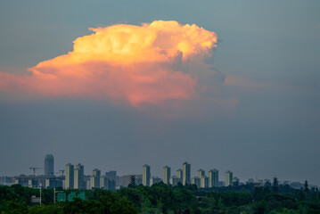 Obraz premium colorful cloud during sunset above city skyline