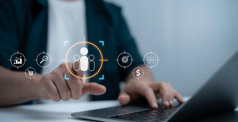 Businessman using laptop with digital customer targeting icons, representing marketing strategy,...