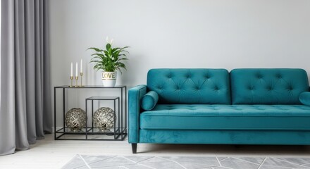 A contemporary living room showcasing a plush turquoise sofa, complemented by minimalist decor, creating a stylish and comfortable home interior