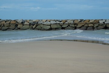 A rocky beach with a wall of rocks on the shore