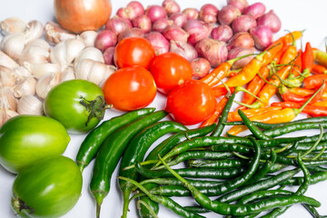 Various raw spices for cooking ingredients on white background; onion, garlic, chili, tomato