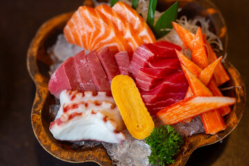Japanese Sashimi Set Menu, a set of freshly sliced ​​fish on ice including fresh salmon, tuna, crab sticks and sweet eggs, in the restaurant.