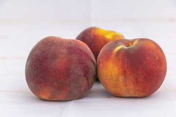 Fresh ripe peaches with fuzzy skin on white background closeup