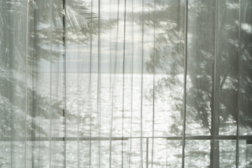 An old, dirty glass window with a textured pattern of water drops and a hint of blue winter light creates a vintage backdrop