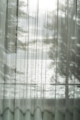 An old, dirty glass window with a textured pattern of water drops and a hint of blue winter light creates a vintage backdrop
