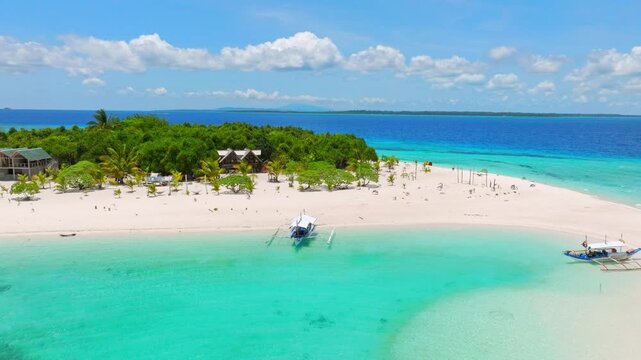 Experience the breathtaking beauty of Balabac Island's white sandy beach and clear blue waters captured from an aerial perspective using a drone.