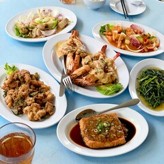 Multiple Chinese dishes spread out on a light blue table.