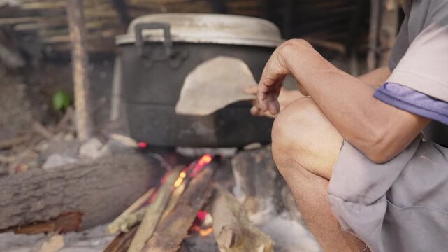 Palm wine farmer cooking fermented sap, distillation in traditional distillery on firewood, in rural flores indonesia, arak, sopi, alcohol