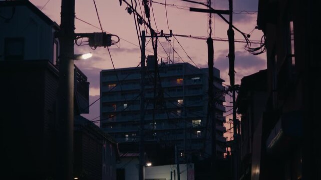 Colorful Tokyo Sunset Framed by Urban Power Grid and Housing &ndash; Radiant twilight sky contrasts with silhouettes of residential blocks and thick cable networks.