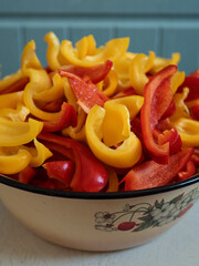 Enamel Bowl Overfilled with Sliced Red and Yellow Bell Peppers for Homemade Preserves