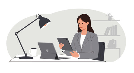 Businesswoman working at desk with tablet and laptop in modern office environment