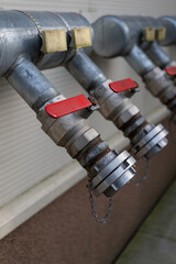 Outdoor connection point on a house facade for fire hose attachment.
