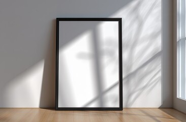 Blank framed poster on a wall with natural light
